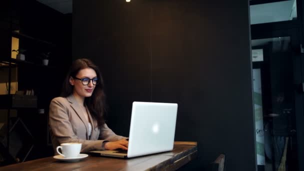 Bella donna hipster utilizzando il computer portatile al caffè — Video Stock