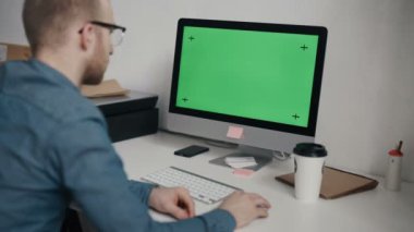 Klavyede yazarak ve yeşil ekrana bakarak beyaz işçi