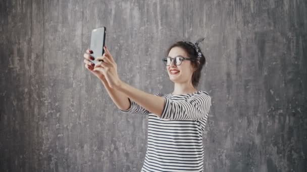 Brunette vrouw in hipster outfit zittend op stappen en het nemen van de selfie. — Stockvideo