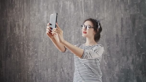 Brunette vrouw in hipster outfit zittend op stappen en het nemen van de selfie. — Stockvideo