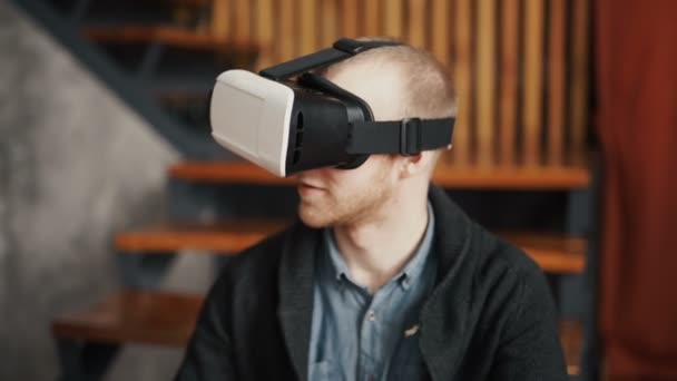 Hombre con gafas de realidad virtual. Tiro de estudio, fondo gris — Vídeos de Stock