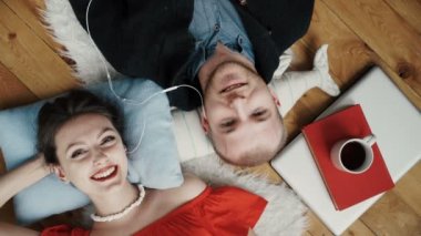 Genç çift bir halı üzerinde kulaklık ile müzik dinlemek