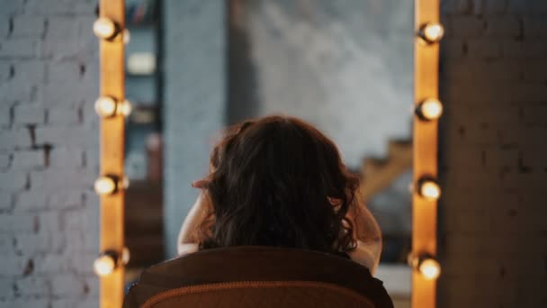 Rozjímání nad mladou krásnou ženou, která si nanáší make-up, dívá se do zrcadla — Stock video