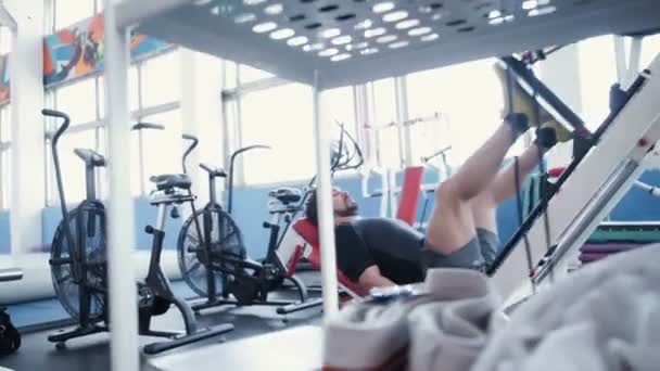 Hombre haciendo ejercicio en la máquina de prensa de piernas — Vídeos de Stock