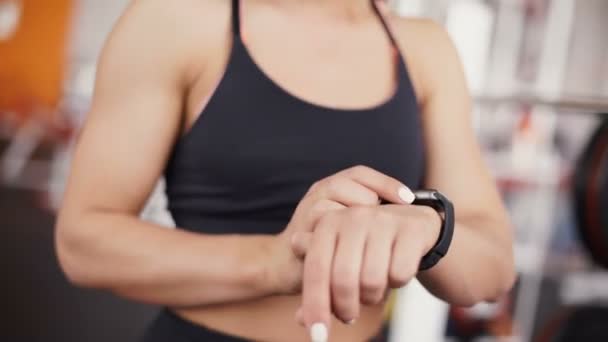 Reloj inteligente que muestra una frecuencia cardíaca de la mujer que hace ejercicio en el gimnasio — Vídeos de Stock