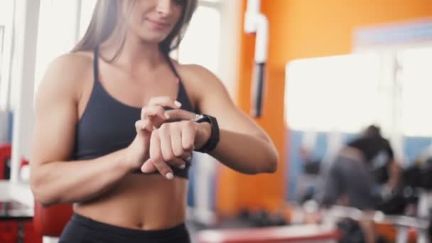 Reloj inteligente que muestra una frecuencia cardíaca de la mujer que hace ejercicio en el gimnasio — Vídeos de Stock