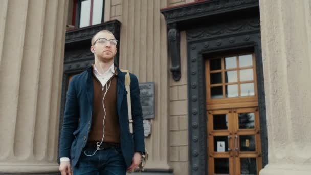 Student leaving college holding his textbooks and rucksack — Stock Video