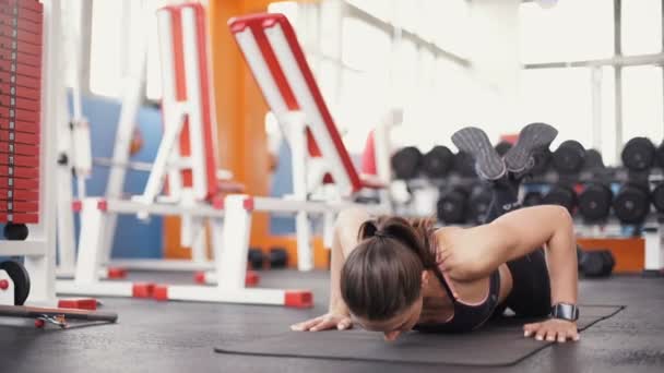 Bruneta žena v tělocvičně tlačit nahoru push-up cvičení cvičení — Stock video