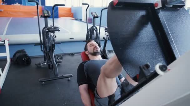 Adam bacak basın makinede egzersiz — Stok video