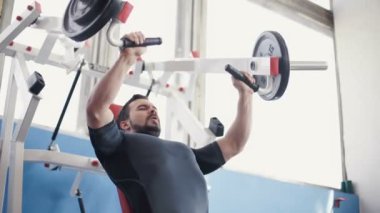 Göğüs kasları spor salonu makinede esneme kulaklık ile genç adam