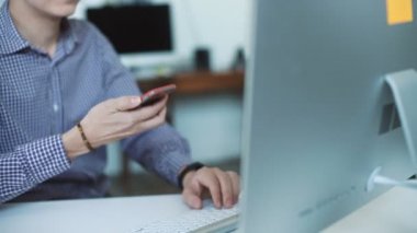 oung adam akıllı telefon ve dizüstü bilgisayar kullanarak evden çalışma