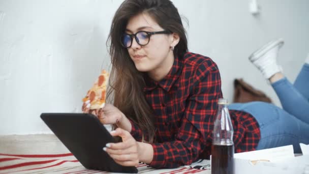 Ασιατική γυναίκα τρώει πίτσα και κοιτάζοντας ψηφιακή δισκίο υπολογιστή στο σπίτι — Αρχείο Βίντεο