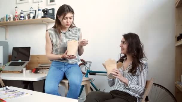 Jóvenes empresarias sonrientes almorzando en la mesa en la oficina — Vídeo de stock