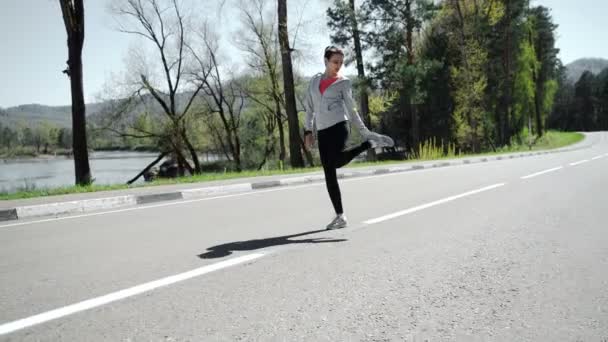 Жінка бігун розігрівається на відкритому повітрі — стокове відео