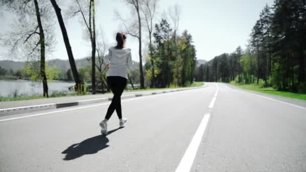 Corredor femenina trotando en el entrenamiento de carretera de montaña para maratón . — Vídeo de stock