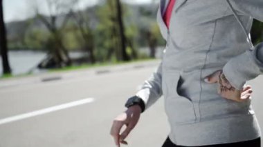 Kadın koşmak için fitness akıllı saatini kuruyor.