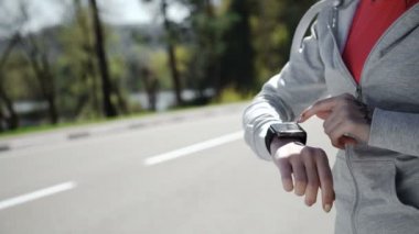 Kadın koşmak için fitness akıllı saatini kuruyor.