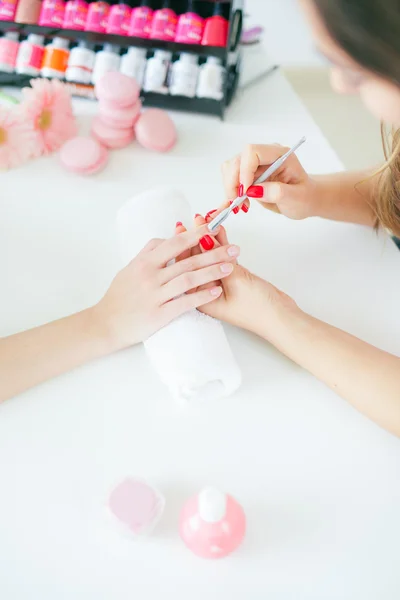 Mujer en salón recibiendo manicura por uña esteticista — Foto de Stock