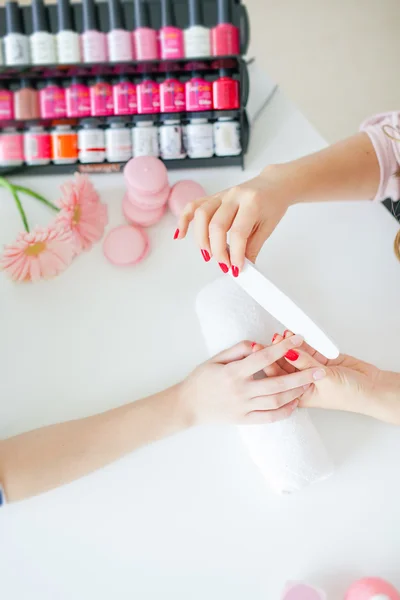 Woman in salon receiving manicure by nail beautician — Stock Photo, Image