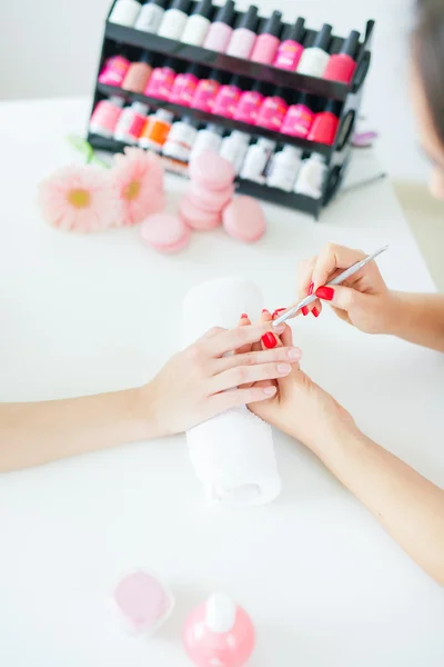 Mulher no salão recebendo manicure por esteticista de unhas — Fotografia de Stock