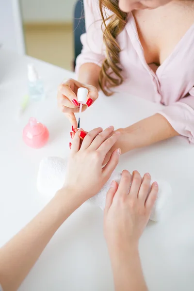 Mulher no salão recebendo manicure por esteticista de unhas — Fotografia de Stock