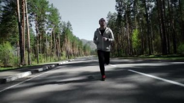 Doğada dışında onun darbede smartwatch ile yolda seyir koşan adam.