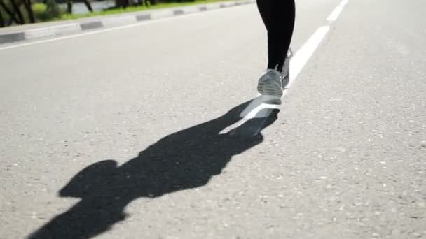 Slow Motion sportieve vrouw draait op weg bij zonsopgang. — Stockvideo