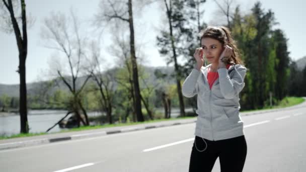 SLOW MOTION ritratto di una giovane donna che fa jogging e ascolta il giocatore — Video Stock