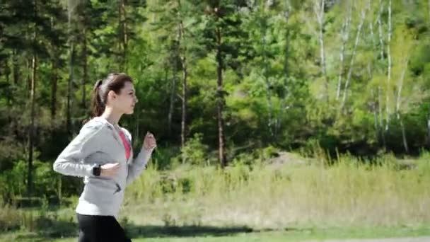 Salud deporte mujer joven correr y mirar desgaste dispositivo de reloj inteligente — Vídeos de Stock