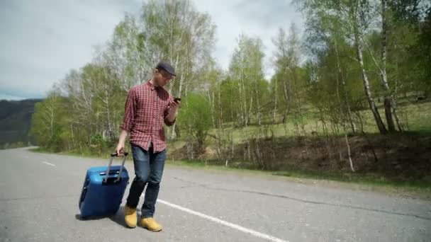 Giovane donna con borsa da viaggio e telefono — Video Stock