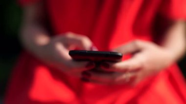 kadın Kırmızı elbiseli bir telefon app mobil cüzdan ile tutarak