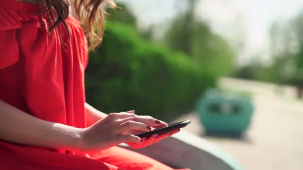 Mujer en vestido rojo sosteniendo un teléfono con monedero móvil aplicación — Vídeos de Stock