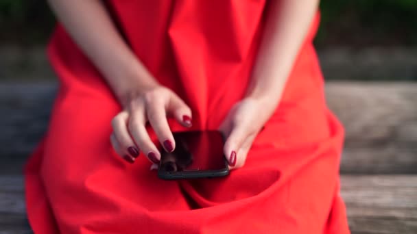 Žena v červených šatech drží telefon s aplikací mobilní Peněženka — Stock video