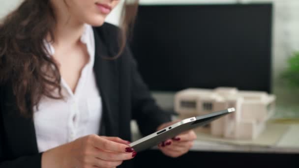 Frau in der Hand ein Tablet mit mobiler Geldbörse. Haus- oder Wohnungsmodell — Stockvideo