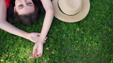 Otların arasında rahatlatıcı. Güzel ve genç birbayan üstten görünüm yeşil çimenlerin üzerinde