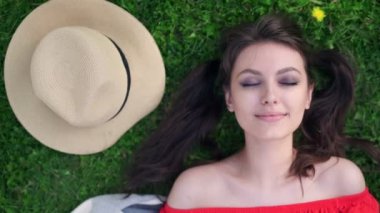 Otların arasında rahatlatıcı. Güzel ve genç birbayan üstten görünüm yeşil çimenlerin üzerinde