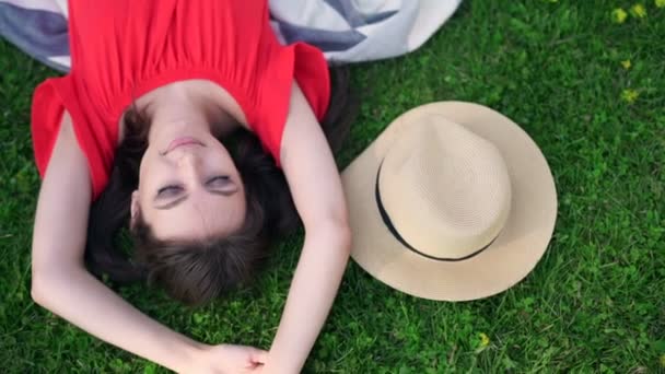 Ontspannen in gras. Bovenaanzicht van mooie jonge vrouw op het groene gras — Stockvideo