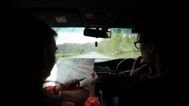 Slowmotion. Nézet hátulról lövés egy fiatal pár, road trip, reading Térkép — Stock videók