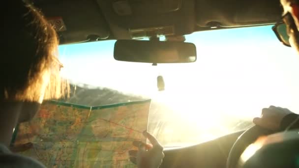 Mujer sosteniendo el mapa y mostrando el mapa de ruta a su novio conduciendo el coche . — Vídeos de Stock