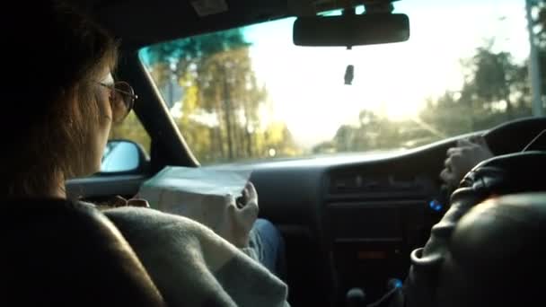 Kvinnan håller karta och visar färdplanen till hennes pojkvän som kör bilen. — Stockvideo