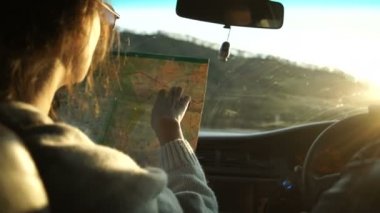 Harita tutarak ve yol haritası sevgilisi arabayı gösterilen kadın.