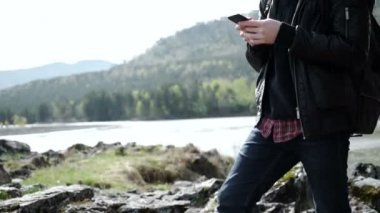 Yakışıklı adam cep telefonu açık tutan nehir kıyısında