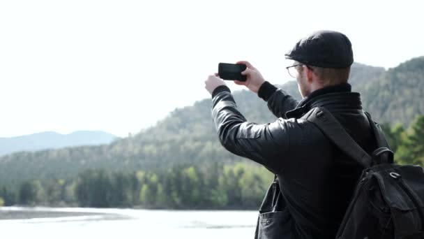 Guy brát fotografie na svůj mobilní telefon fotoaparát krásné krajiny — Stock video