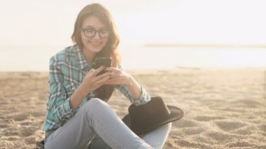 şık genç kadın, bir telefon, kot gömlek ve pantolon holding eller güzel.