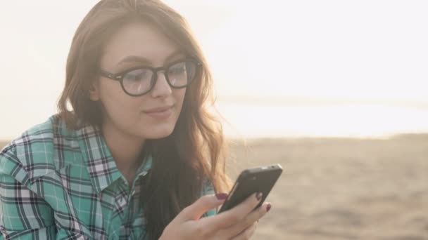 Joven mujer bonita con estilo, manos sosteniendo un teléfono, camisa de mezclilla y jeans — Vídeos de Stock