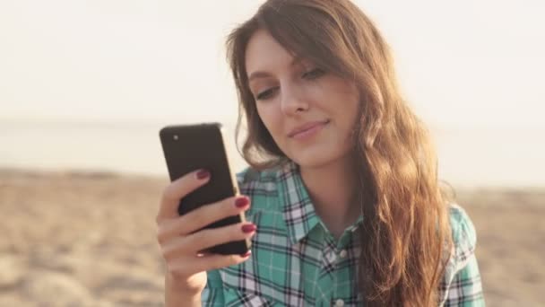 Ung snygg pretty woman, händer som håller en telefon, jeansskjorta och jeans — Stockvideo