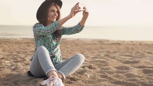 Mooie jonge vrouw doet selfie op het strand — Stockvideo