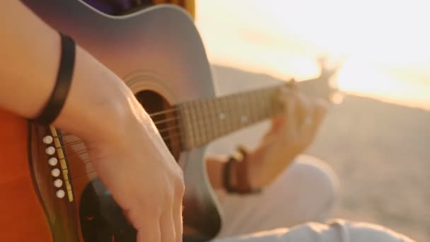 Kleiner Junge spielt bei Sonnenuntergang Gitarre — Stockvideo