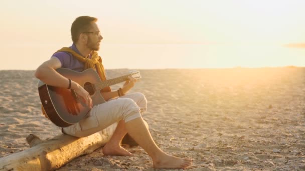 Niño toca la guitarra al atardecer — Vídeo de stock