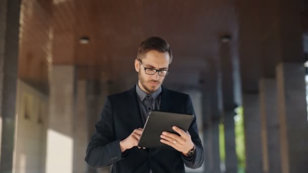 Jovem empresário barbudo escrevendo e-mail de negócios usando seu tablet pc — Vídeo de Stock